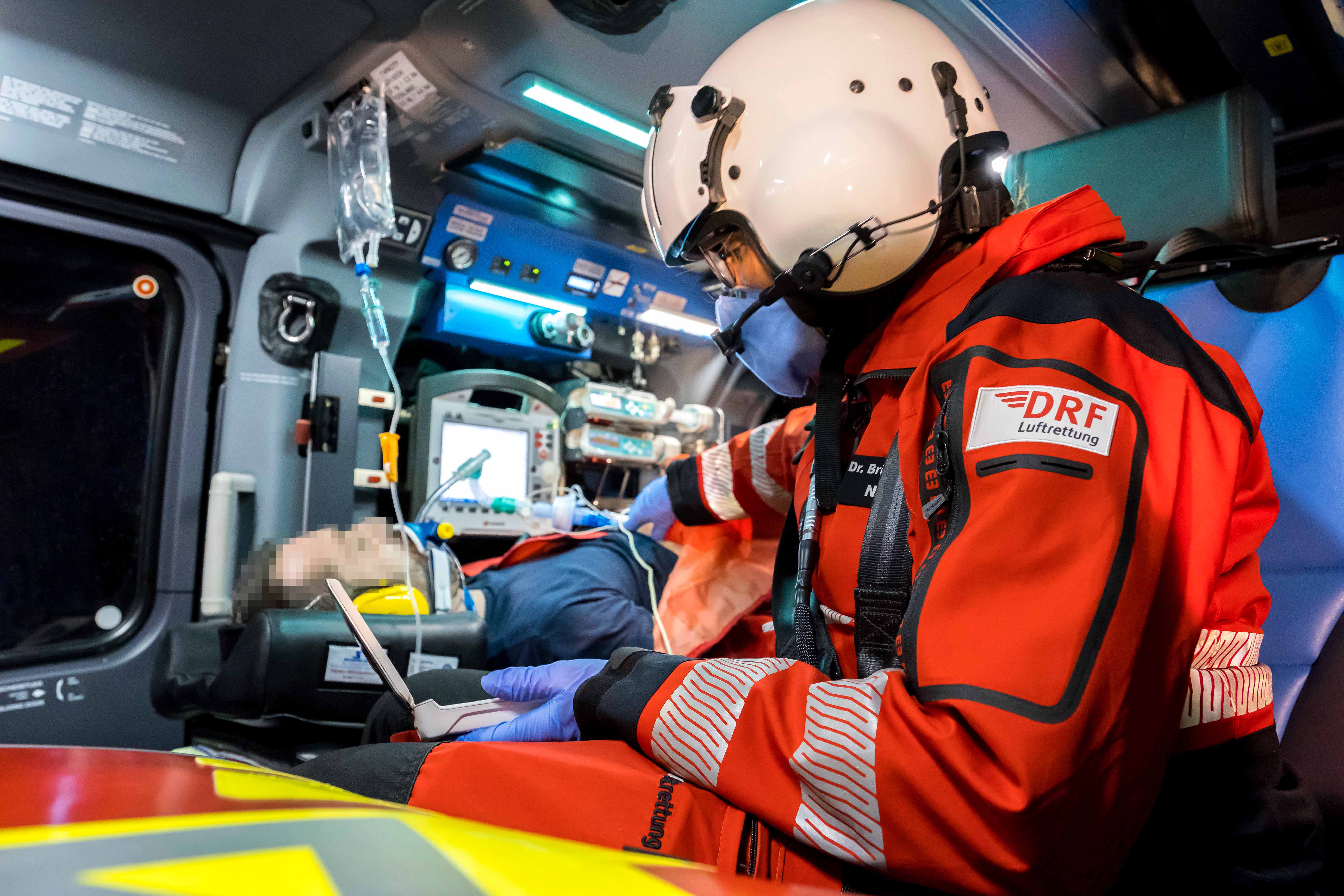 Eine Notärztin untersucht einen Patientin während des Hubschrauberfluges mit einem mobilen Ultraschallgerät
