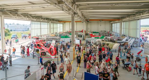 Blick in eine Hubschrauberwerfthalle mit vielen Besuchern vor Ort