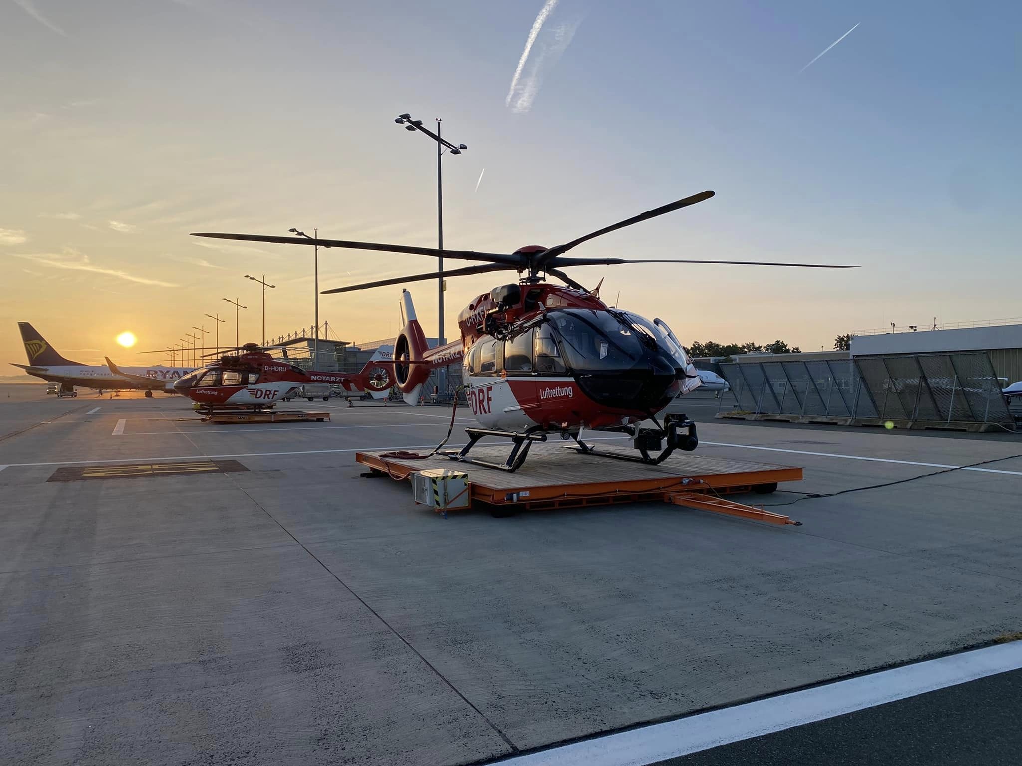 Ein Hubschrauber des Typs H145 mit Fünfblattrotor steht auf einer Plattform bei Sonnenuntergang am Flughafen Nürnberg