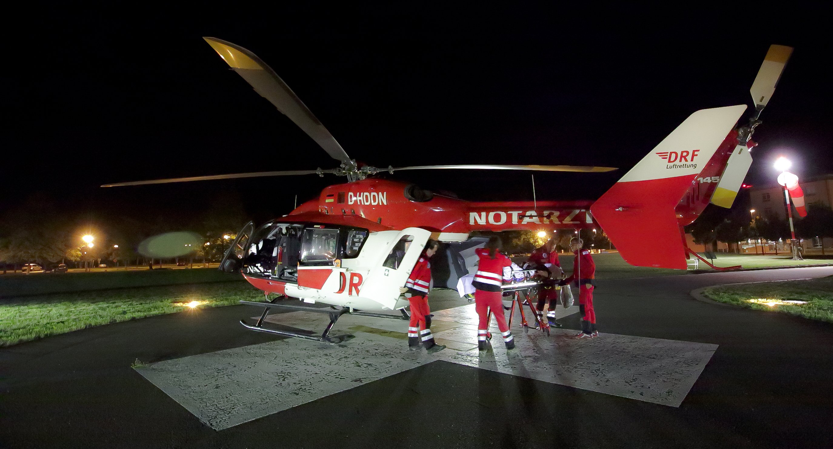 Rot-weißer Hubschrauber auf dem Landeplatz in der Nacht